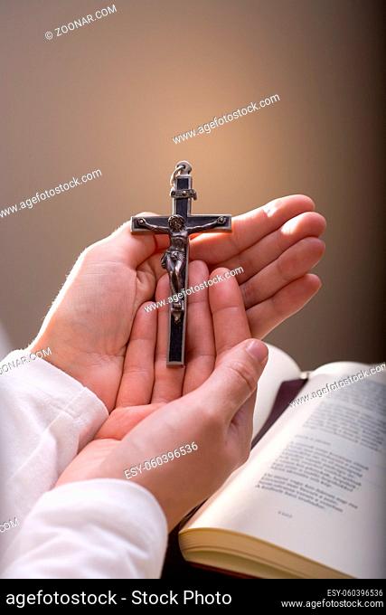 Christian believer holding old cross in hand