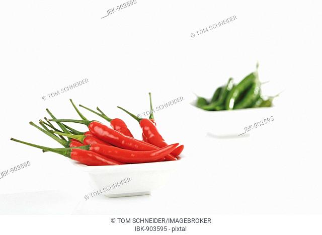 Red and green Thai chillies in bowls