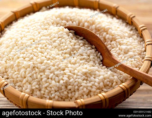 Glutinous rice in a bamboo colander set against a background of trees with copy space