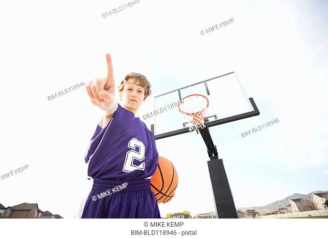 Caucasian basketball player holding out finger on court
