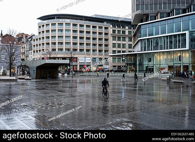 Brussels Old Town, Belgium - March 12, 2023 - The La Monnaie square with the Esprit and other fashion stores in the rain