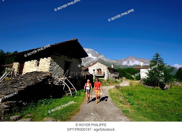 COUPLE OF HIKERS IN THE HAMLET OF LE MONAL, IN THE BACKGROUND MONT POURRI IN SAINTE FOY TARENTAISE, (73) SAVOY, RHONE ALPES, FRANCE
