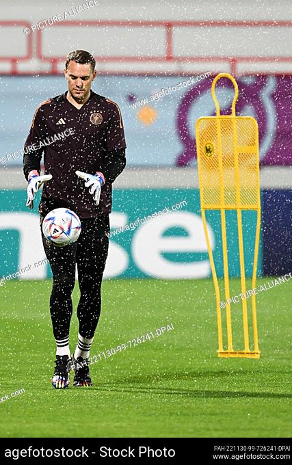 30 November 2022, Qatar, Al-Shamal: Soccer, World Cup 2022 in Qatar, training Germany, goalkeeper Manuel Neuer stands with a ball next to a training dummy