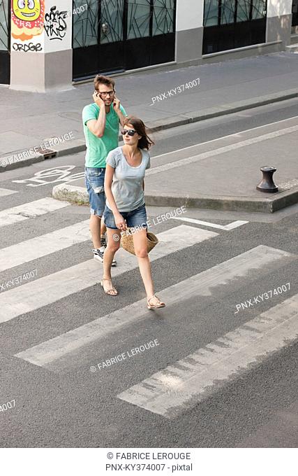 Couple walking on a road, Paris, Ile-de-France, France