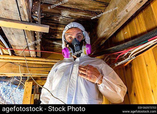 A close up and front portrait of a man wearing PPE personal protective equipment inside a basement