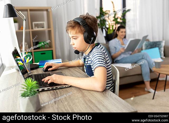 boy with laptop and headphones at home