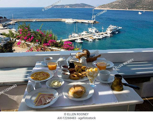 Breakfast including locally made pastries served on a terrace overlooking Platis Ghialos; Sifnos, Cyclades, Greek Islands, Greece