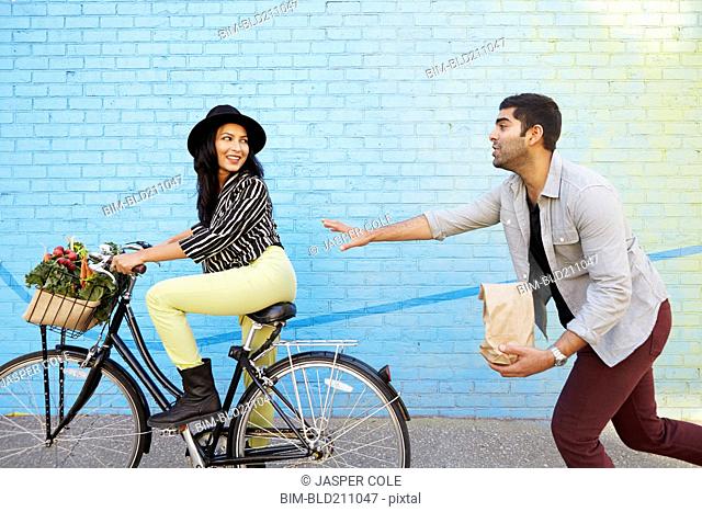 Indian man chasing girlfriend on bicycle
