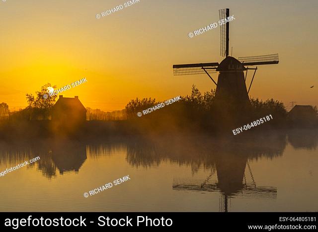 Traditional Dutch windmills with a colourful sky just before sunrise in Kinderdijk, The Netherlands