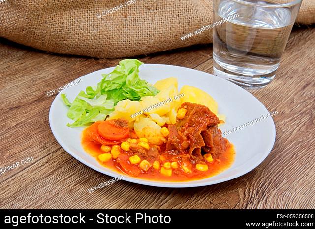 Mexican goulash with potatoes on a wooden table