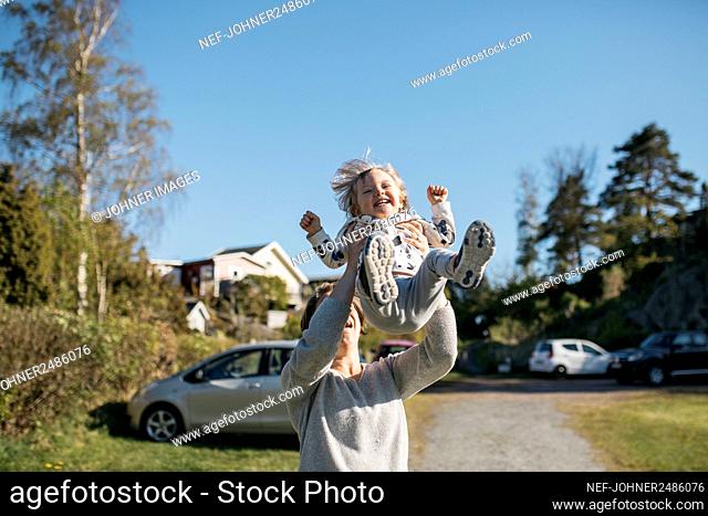 Mother throwing girl in air
