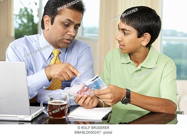 Middle Eastern father and son counting money