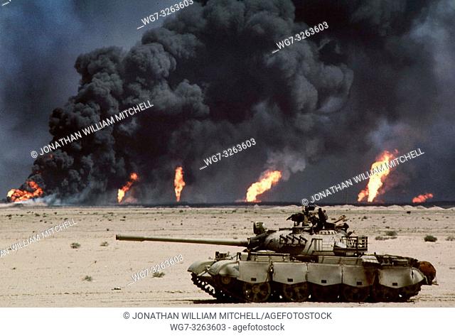 IRAQ - 1990 - An abandoned Russian-made tank in the desert in front of burning oil wells, images like these became an icon of the first Gulf War in 1990