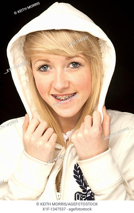 A slim blonde 14 year old teenage girl with dental braces on her teeth, UK