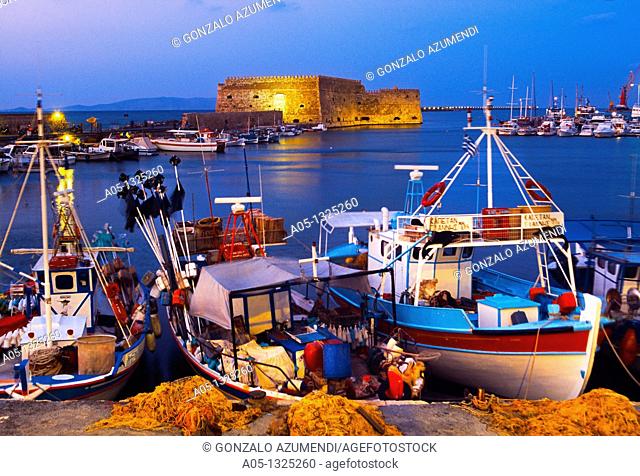 Cretan boat moored Heraklion harbour and Venetian fortress Koules Castle, Iraklio, Crete, Greece