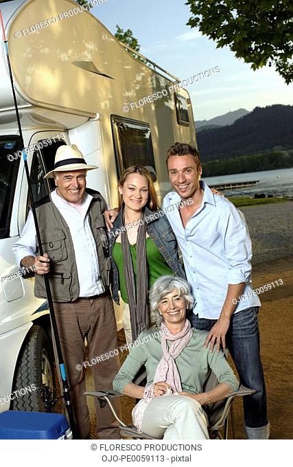 Two couples outside recreational vehicle with fishing pole