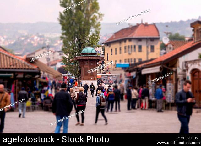 View of Bascarsija square with Sebilj wooden fountain, local businesses, locals and tourists in Old Town Sarajevo, capital city of Bosnia and Herzegovina
