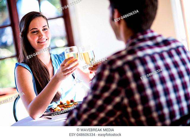 Couple toasting white wine glass in restaurant