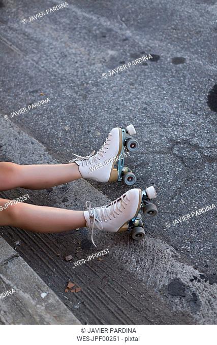 Young woman with roller skates on lane, partial view