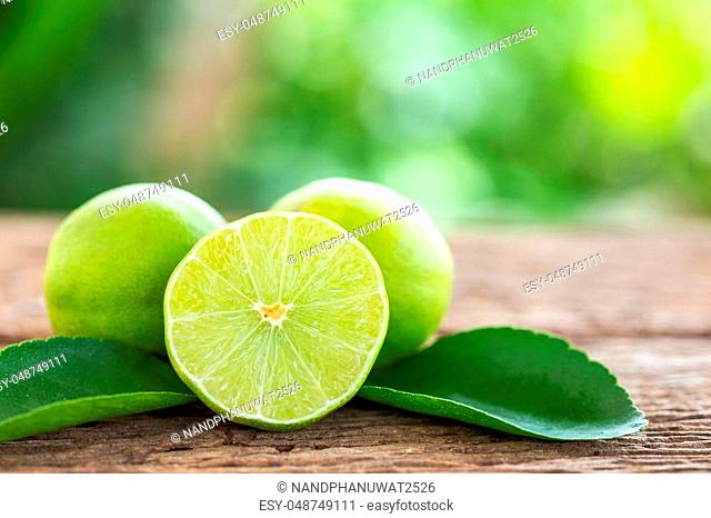 Close up slice green fresh lemon on wooden table background