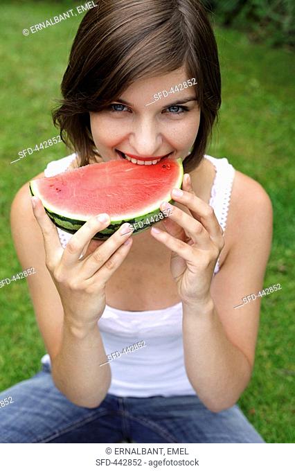 Young woman biting into a slice of watermelon