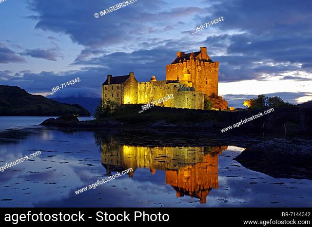 Castle with bridge is lit differently at dusk, Eilean Donan Castle, Dornie, Highlands, Scotland, United Kingdom, Europe