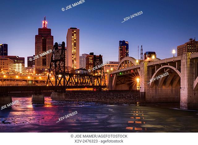 Ice covered Mississippi River and St. Paul skyline with railroad bridge and Roberts Street bridge at dusk