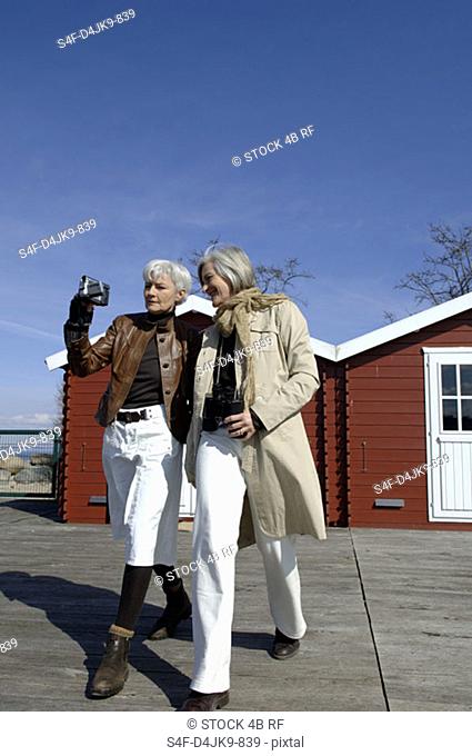 Two mature women using a camcorder
