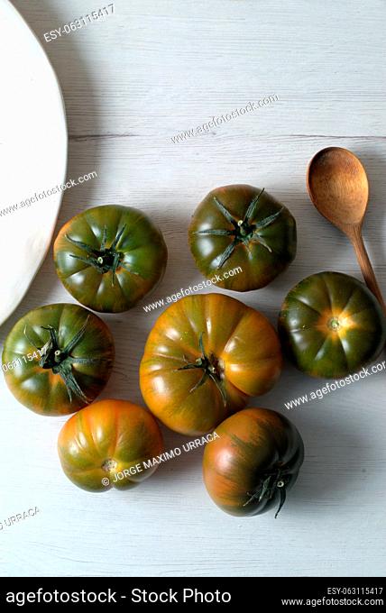 Green salad tomatoes on white kitchen board