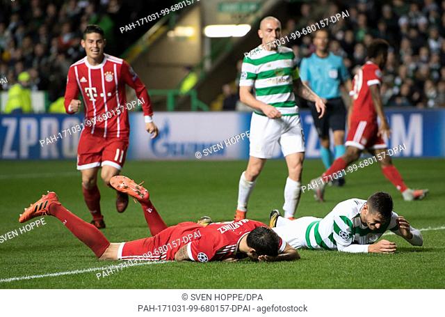 Javi Martinez (L) of Bayern and Glasgow's Nir Bitton lie on the ground injured during the Champions League football match between Glasgow's Celtic FC and FC...