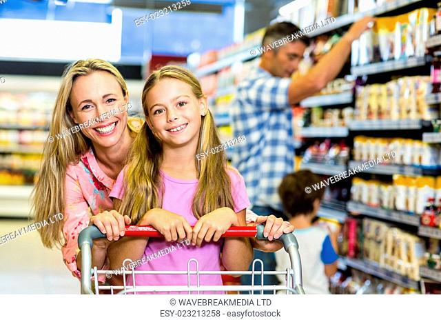Smiling mother and daughter at the supermarket