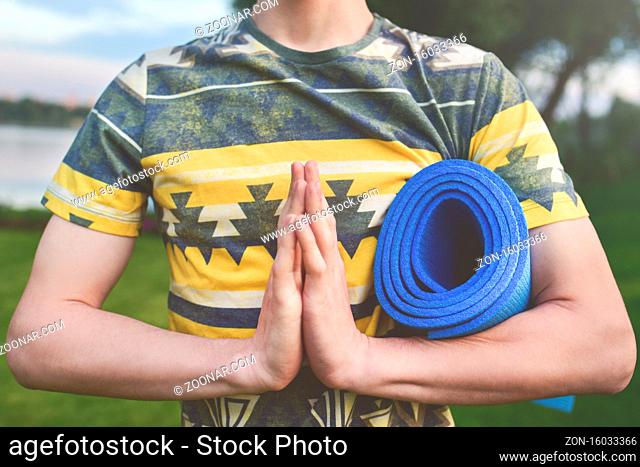 Yoga. Close up men hands. Young men do yoga outdoors on mat.Guy exercising yoga on the garden.Young men meditating in lotus posture closeup. zen