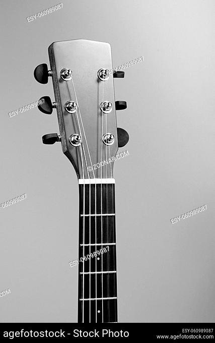 The fretboard of an acoustic guitar closeup. Studio photo of a musical instrument. Guitar-themed background or Wallpaper with space to copy. Mockup