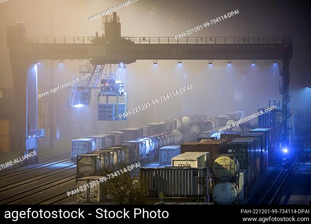 01 December 2022, Saxony, Leipzig: A crane is used to reload containers at the Leipzig-Wahren transshipment terminal in the early morning