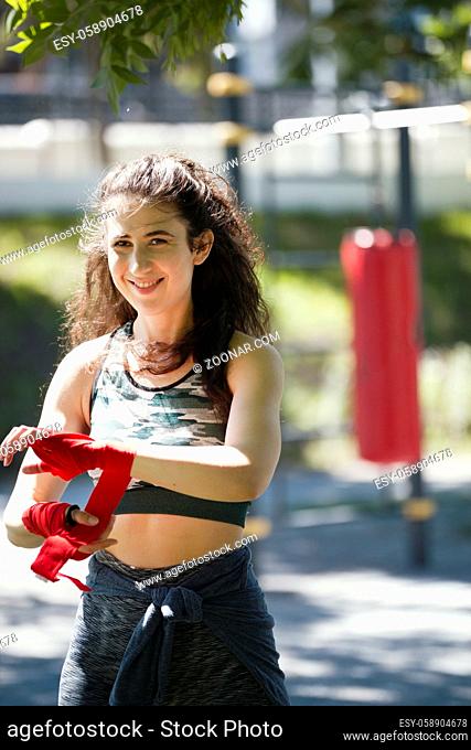 Portrait of young woman - box spotsman in summer park during work out training, close up