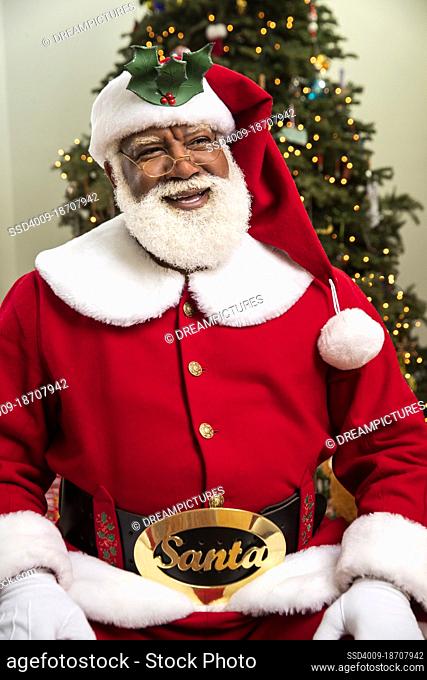 Black Santa Claus portrait in front of Christmas tree