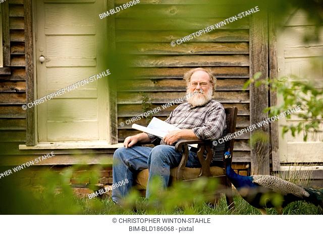 Caucasian man sitting in armchair outdoors