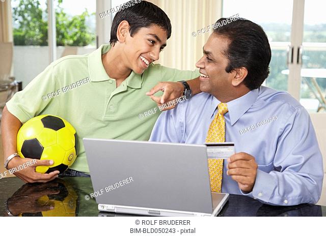 Middle Eastern father and son shopping online