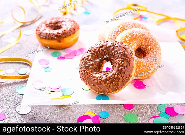 Donuts with streamers and confetti. Donuts for carnival and party. Colorful carnival or birthday image