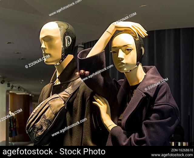 Paris, France - December 20, 2018: Showcase of an expensive clothing store. Futuristic-looking mannequins (cyborgs) in fashionable and expensive clothes