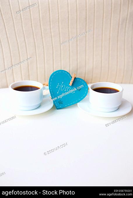 two cups of coffee on the table that says home
