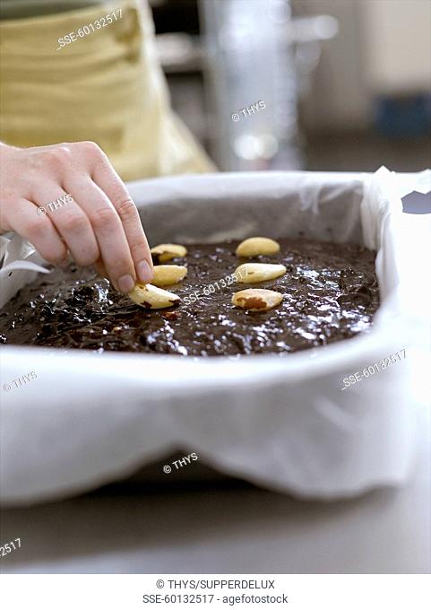 Fill the cake tin with the mixture and decorate with the brazil nuts