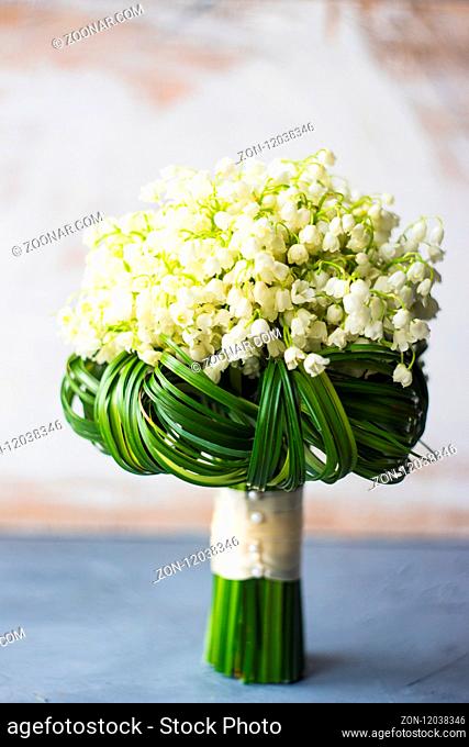 Beautiful may lilies in bride bunch on rustic background with copy space