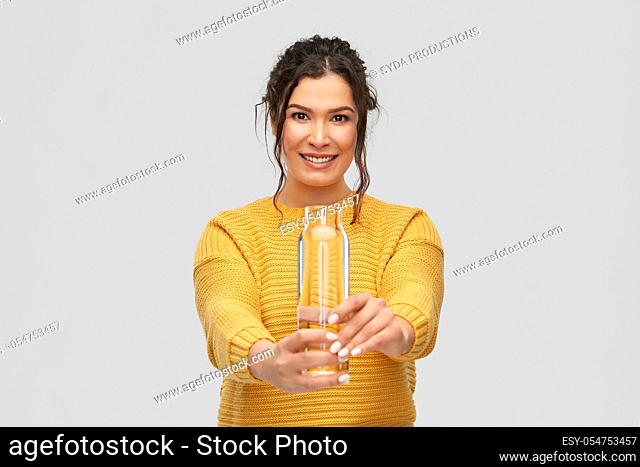 smiling young woman with water in glass bottle