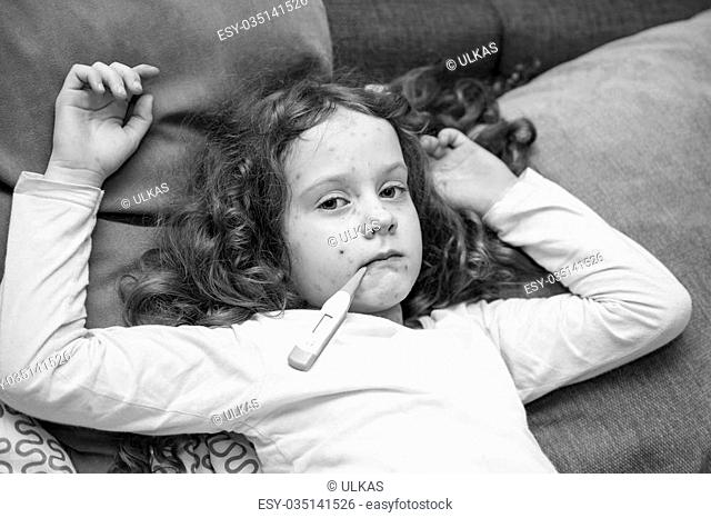 Child measuring temperature. Varicella zoster virus or Chickenpox. Black and white portrait