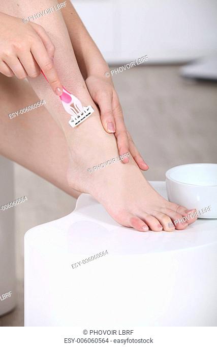 woman shaving her leg