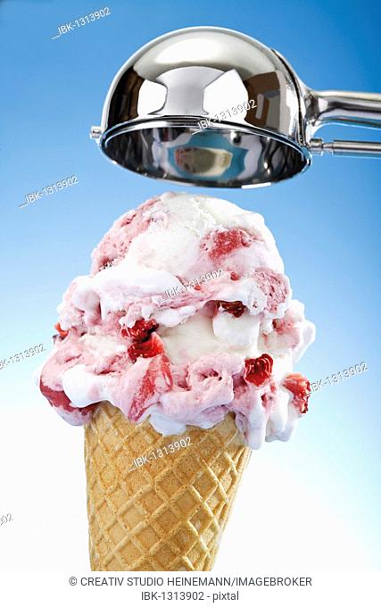 Ice-cream cone with strawberry ice cream and a scoop