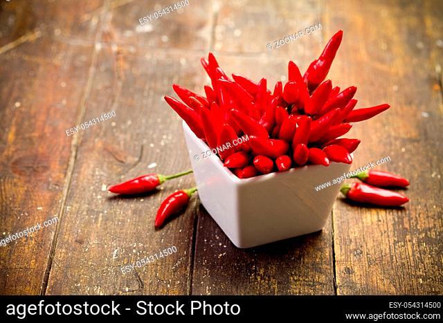 photo of red hot chili peppers inside a bowl on wooden table