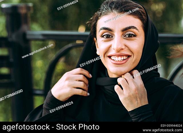 Cinematic image of a woman from the emirates with her children having fun at the playground