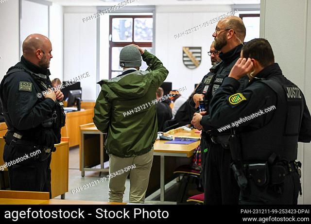 11 December 2023, Saxony, Chemnitz: One of the six defendants (M) arrives at Chemnitz district court before the start of the trial in connection with riots and...